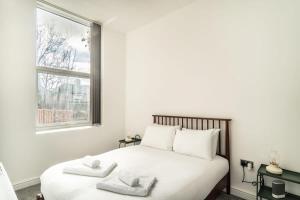een slaapkamer met een bed met twee handdoeken erop bij Modern 2 Bed Apartment in Waterloo Liverpool in Liverpool