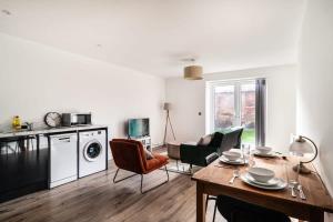 a kitchen and living room with a table and chairs at Modern 2 Bed Apartment in Waterloo Liverpool in Liverpool