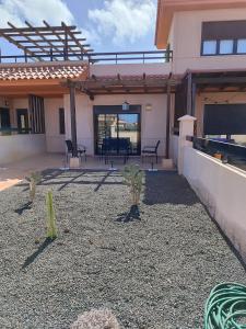 a patio of a house with cactuses in the yard at Villa Punta Calma in Majanicho +27 photos