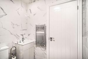Baño blanco con lavabo y aseo en Modern 2 Bed Apartment in Waterloo Liverpool en Liverpool