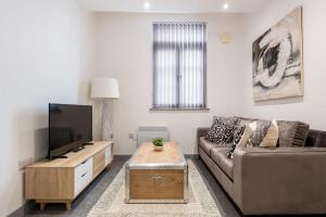 een woonkamer met een bank en een flatscreen-tv bij 1 Bedroom Budget Apartment in Central Doncaster in Doncaster
