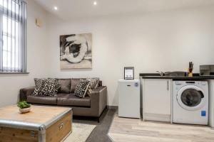 a living room with a couch and a washer and dryer at 1 Bedroom Budget Apartment in Central Doncaster in Doncaster
