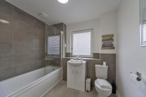 Un baño con bañera, inodoro y lavabo. en Stylish and Bright 2 Bed Apartment in Ashford, en Ashford