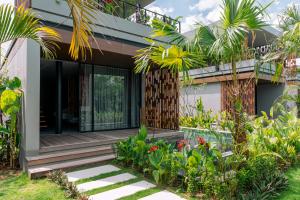 a house with a courtyard with plants and trees at BASK Gili Meno in Gili Meno