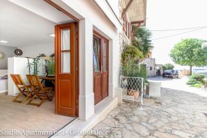 a front door of a house with a table and chairs at Casanova Apartments - Viewpoint in Vrsar