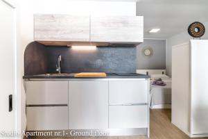 a kitchen with white cabinets and a sink at Casanova Apartments - Viewpoint in Vrsar +69 photos