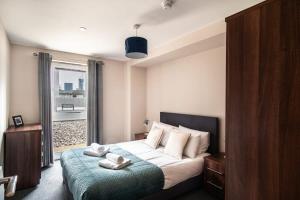 - une chambre avec un lit et une grande fenêtre dans l'établissement Bright & Modern 2 Bed Apartment in Manchester, à Manchester