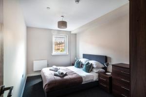 a bedroom with a bed with blue pillows at Spacious & Modern 2 Bed Apartment in Manchester in Manchester