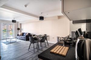 eine Küche und ein Wohnzimmer mit einem Sofa und einem Tisch in der Unterkunft Spacious & Modern 2 Bed Apartment in Manchester in Manchester