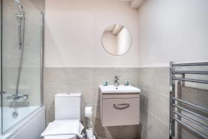 a bathroom with a toilet and a sink and a mirror at Spacious & Modern 2 Bed Apartment in Manchester in Manchester
