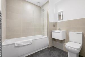 a bathroom with a toilet and a tub and a sink at Modern 2 Bedroom Apartment in Central Newbury in Newbury