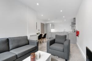 een woonkamer met een bank en 2 stoelen en een keuken bij Modern 2 Bedroom Apartment in Central Newbury in Newbury