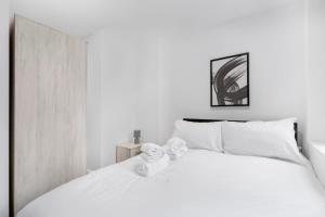 a bedroom with a white bed with towels on it at Modern 2 Bedroom Apartment in Central Newbury in Newbury