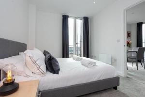 a bedroom with a bed with white sheets and pillows at Spacious 2 Bed Apartment in Central Manchester in Manchester