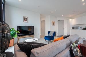 a living room with a couch and a tv at Spacious 2 Bed Apartment in Central Manchester in Manchester