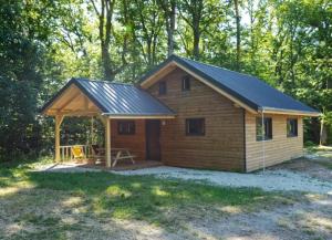 Cabaña de madera pequeña con techo de gambrel en Camping Osenbach, en Osenbach
