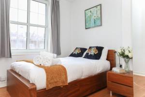 a bedroom with a bed with white sheets and a window at Lovely 2 Bedroom Apartment in Central London in London