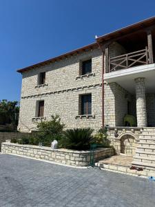 un gran edificio de ladrillo con ventanas y una escalera en Alibeja villa en Pashalli
