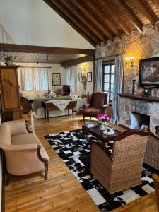 a living room filled with furniture and a stone fireplace at Rose Garden Platres in Platres