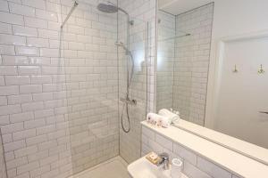 a white bathroom with a shower and a sink at Superb 2Bed 2Bath 5min walk to Victoria Station in Manchester