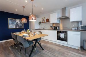 cocina y comedor con mesa de madera y sillas en Amazing 2 Bed Apartment 5min To Old Trafford, en Mánchester