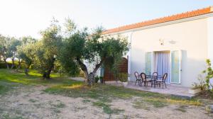 una casa con una mesa y sillas en un patio en Olive Τrees Garden, en Lixouri