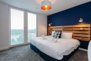 1 dormitorio con 1 cama grande, paredes y ventanas azules en Amazing 2 Bed Apartment 5min To Old Trafford, en Mánchester