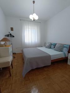 um quarto com uma cama, uma cómoda e uma janela em Apartman Ena em Senj