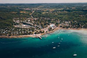 罗维尼Maistra Camping Veštar Pitches的海滩鸟瞰图，水中停泊着船只