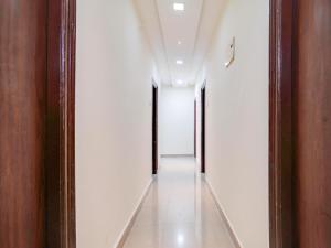 a hallway with white walls and wooden doors at Collection O MS Grand Inn in Hyderabad