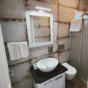 a bathroom with a sink and a toilet and a mirror at Port Hotel, Tasucu in Silifke