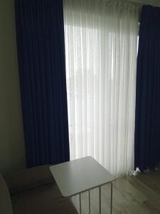 a white table in front of a window with curtains at Port Hotel, Tasucu in Silifke