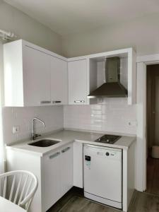 a white kitchen with a sink and a stove at Port Hotel, Tasucu in Silifke