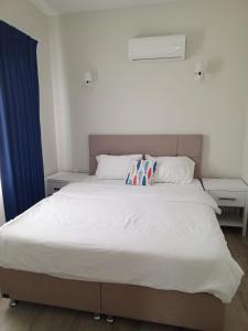 a bedroom with a white bed with a pillow on it at Port Hotel, Tasucu in Silifke