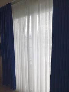 a window with white curtains and a blue at Port Hotel, Tasucu in Silifke