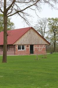 un granero de ladrillo rojo con techo rojo en Weitblick - Ruhepol in münsterländer Parklandschaft, en Dulmen