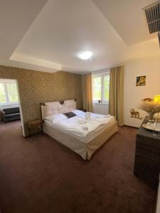 a bedroom with a large white bed in a room at Malkia Penzion in Orechová Potôň