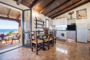 cocina y comedor con mesa y sillas en Casa Mariano, en Costa Rei