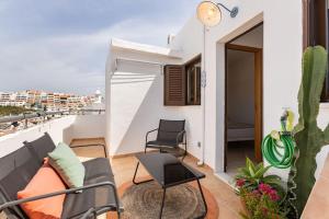 un patio con divano e sedie sul balcone. di Casinha da Jade ad Albufeira