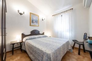 1 dormitorio con cama, mesa y ventana en Casa Mariano, en Costa Rei