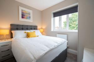 a bedroom with a large white bed with a window at Cosy 3 Bedroom Home in Birmingham with Garden in Birmingham