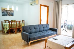 トレビエハにあるApartamento en Torreviejaのリビングルーム(青いソファ、テーブル付)