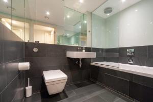 ein Badezimmer mit einem WC, einem Waschbecken und einem Spiegel in der Unterkunft Spacious and Modern 1 Bedroom Apartment in Chelsea in London