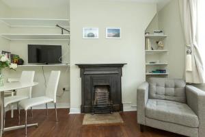 uma sala de estar com uma cadeira e uma lareira em Lovely 2 Bedroom Apartment in Waterloo em Londres