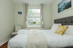 um quarto com uma grande cama branca e uma janela em Lovely 2 Bedroom Apartment in Waterloo em Londres