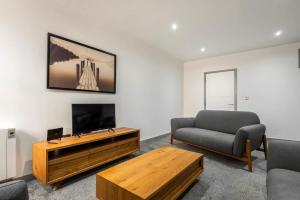 uma sala de estar com uma televisão, um sofá e uma mesa em Modern 3 Bed Budget Apartment in Central Doncaster em Doncaster