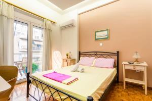 Un dormitorio con una cama con toallas rosas. en Athens Perfect Spot - Zografou Cozy Home, en Atenas