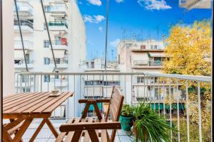 balcón con mesa de madera y 2 sillas en Athens Perfect Spot - Zografou Cozy Home, en Atenas