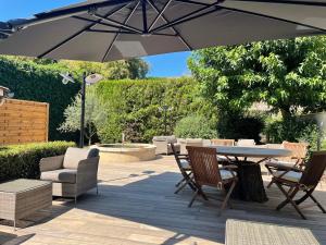 une terrasse avec une table, des chaises et un parasol dans l'établissement Hotel Restaurant Chartron, à Saint-Donat-sur-lʼHerbasse