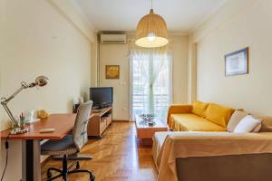 ein Wohnzimmer mit einem gelben Sofa und einem Schreibtisch in der Unterkunft Athens Strawberry Hideaway - City Chic Retreat in Athen